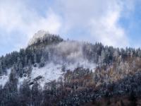 Dünne Wolkenfetzen umschweben einen frisch verschneiten Berggipfel im Priental
